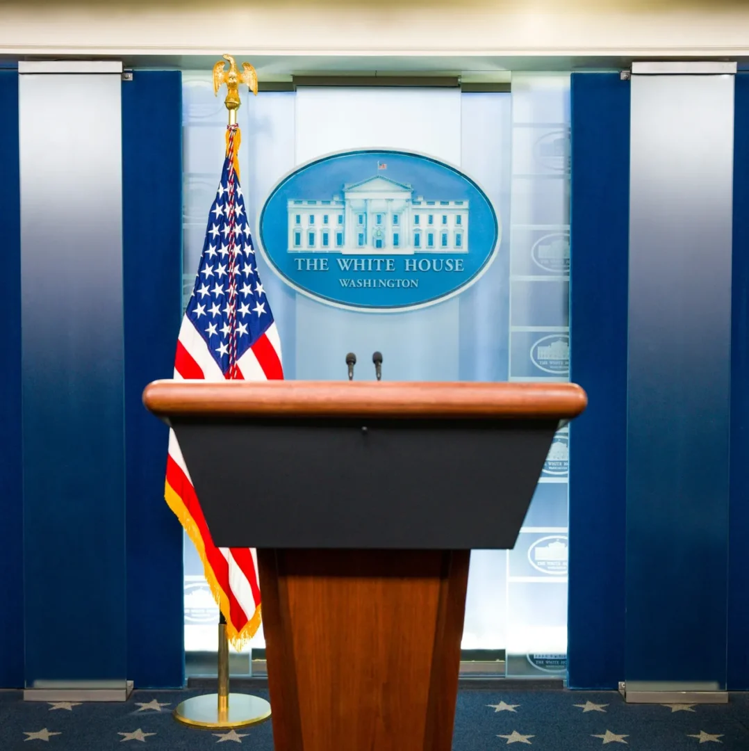 White House press briefing room podium with American flags